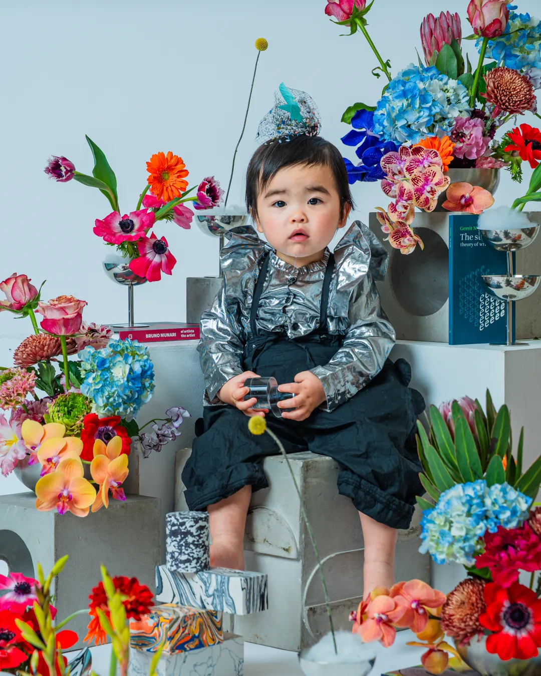 色とりどりの花に囲まれて座る幼児（KIDS & BABY）
