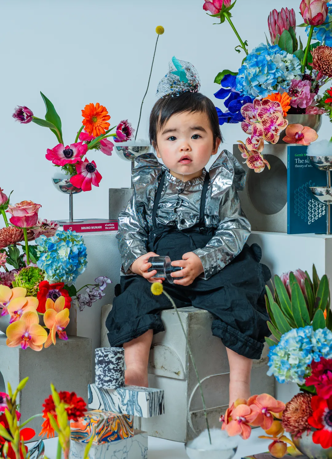 色とりどりの花に囲まれて座るベビー＆キッズのポートレート
