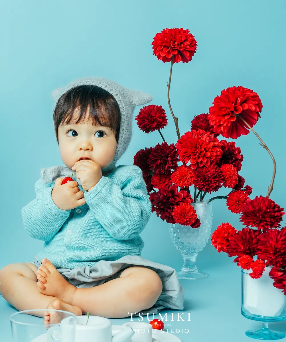 水色の衣装で赤い花を眺める赤ちゃん（Cherry シーン）