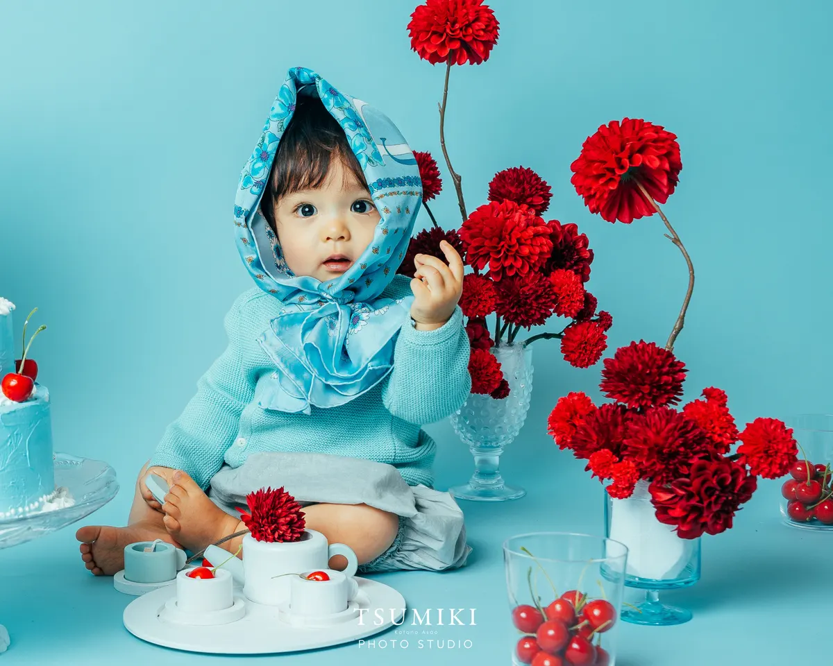 水色のスカーフを巻き赤い花を手にする赤ちゃん（Cherry シーン）