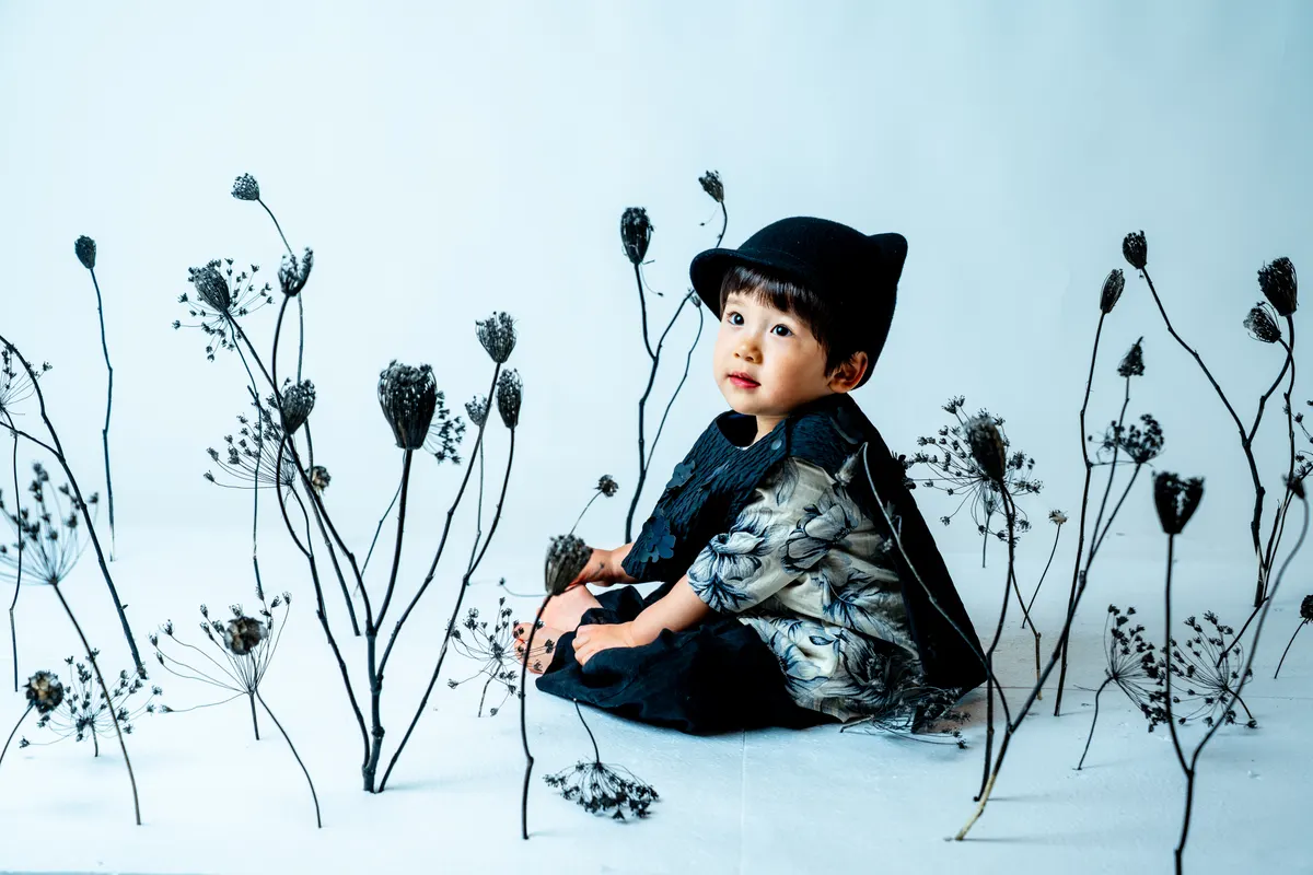 水墨画のような黒い花の世界で写る子ども（Sumikuro シーン）