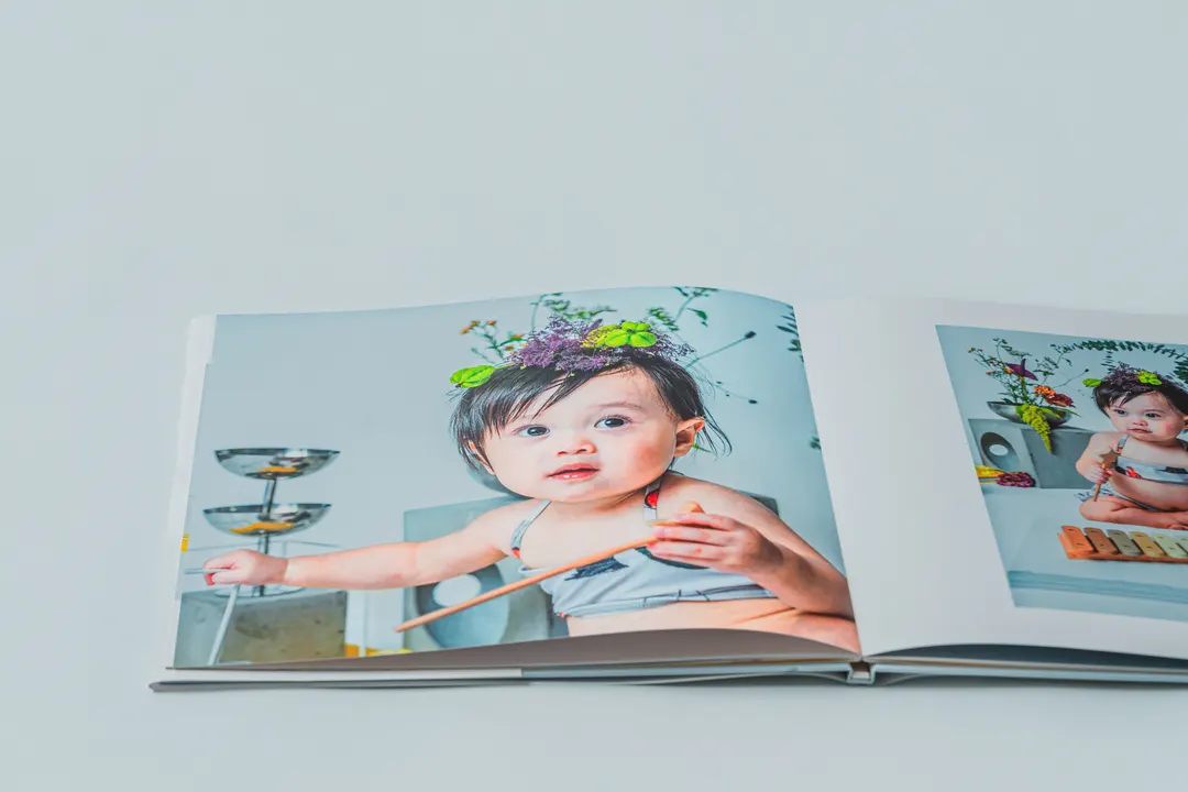 花飾りをつけたベビーが写る Fine Art Album の見開きページ