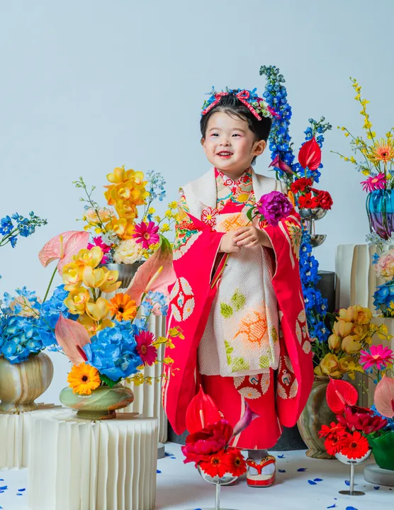 紅色地に鶴柄の着物に白い被布を合わせた「紅鈴」を着た子ども