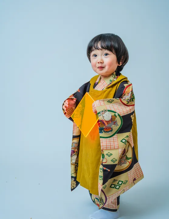 黒とチェック地に童柄の着物「稚児」を着た女の子