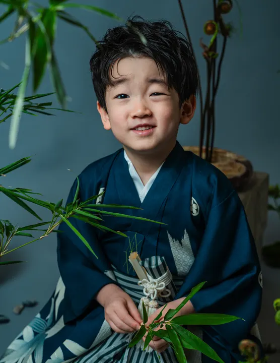 濃紺地に竹柄の羽織に縞袴を合わせた着物「竹林」を着た男の子