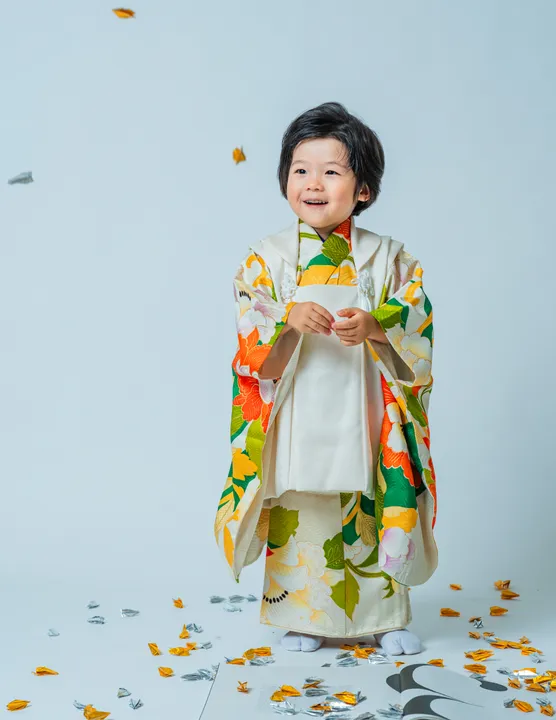 緑地に花柄の着物に白い被布を合わせた「緑華」を着た子ども