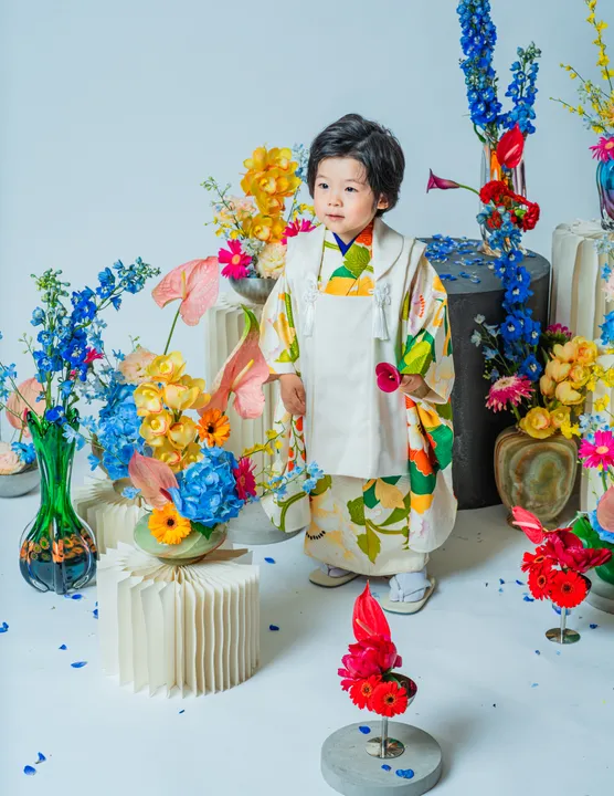 緑地に花柄の着物に白い被布を合わせた「緑華」を着た子ども