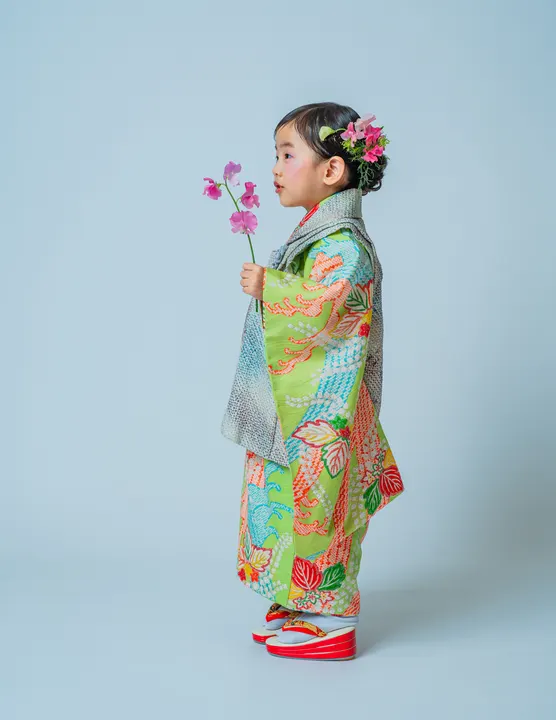 鶯色地に古典柄の着物「鶯」を着た女の子