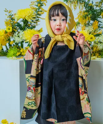 黄色い頭巾と着物姿で黄花を背に立つ七五三の女の子(Bouquet シーン)