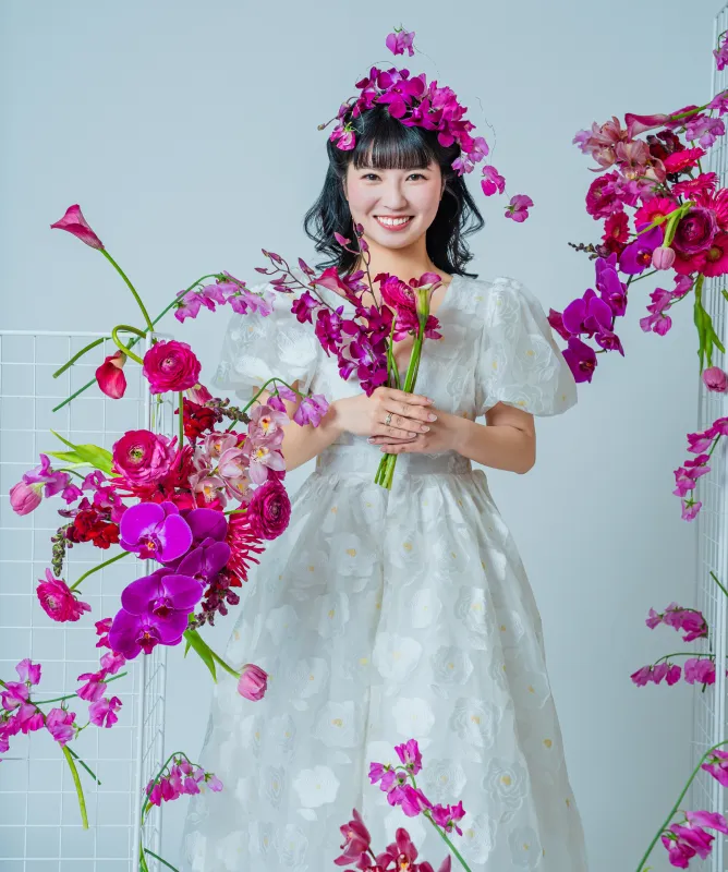 生花のアレンジに囲まれて花束を抱える花嫁(Bouquet シーン)