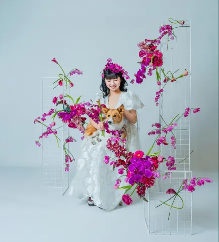 生花のアーチの中でコーギー犬を抱く花嫁(Bouquet シーン)