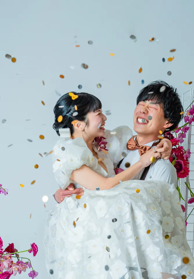 舞い散るコンフェッティの中で抱き合って笑う新郎新婦(Confetti シーン)