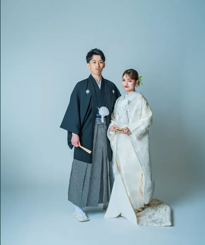 黒紋付袴の新郎と白無垢の花嫁が並ぶ全身(和装シーン)