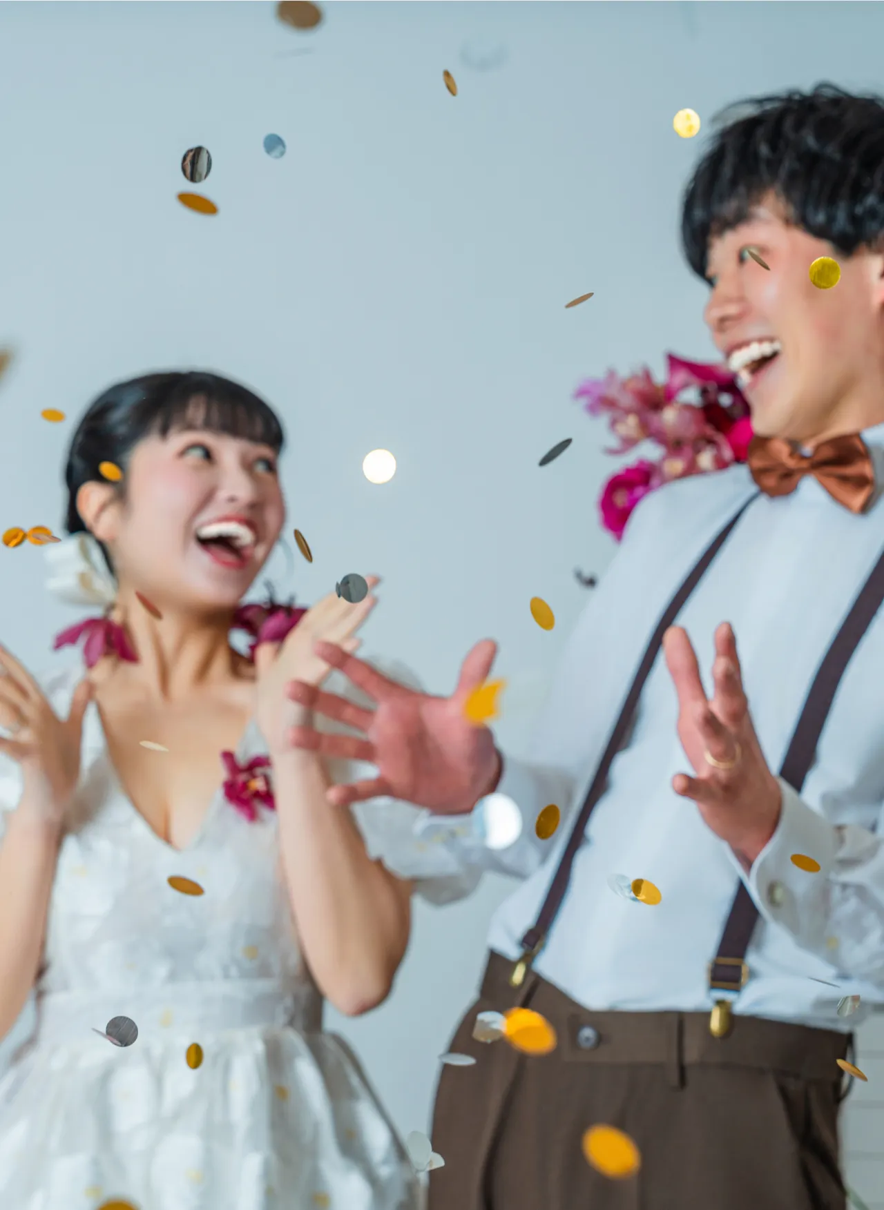 舞い散るコンフェッティの中で笑い合う新郎新婦